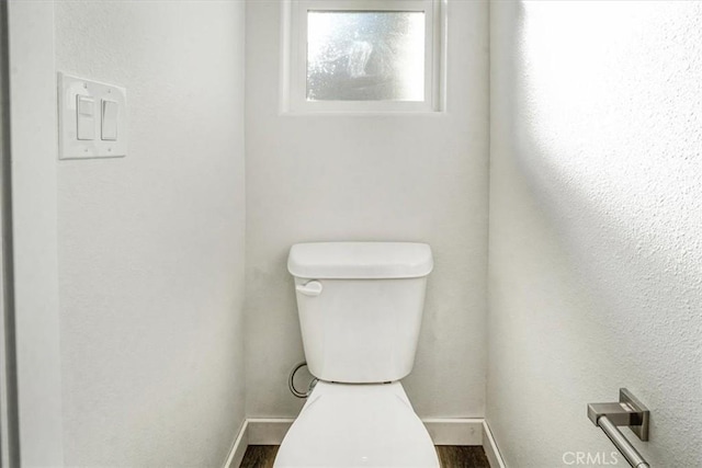 bathroom featuring wood-type flooring and toilet