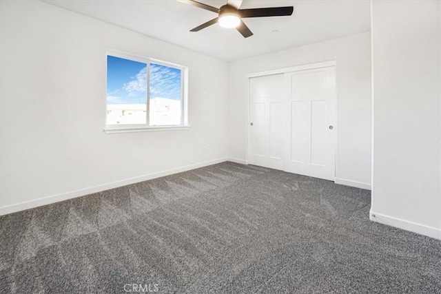 unfurnished bedroom featuring a closet, ceiling fan, and dark colored carpet