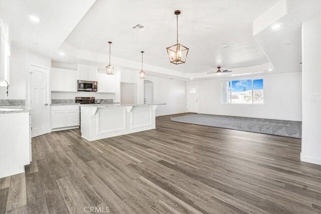 kitchen featuring white cabinetry, pendant lighting, a raised ceiling, and ceiling fan