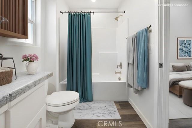 full bathroom with vanity, toilet, hardwood / wood-style floors, and shower / bath combo with shower curtain