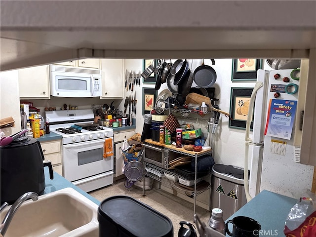 kitchen with white cabinetry, sink, and white appliances