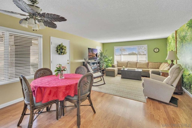 dining space featuring ceiling fan, a textured ceiling, and light hardwood / wood-style flooring