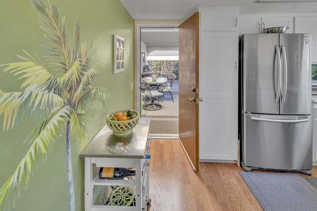 kitchen with white cabinetry, stainless steel fridge, and light hardwood / wood-style flooring