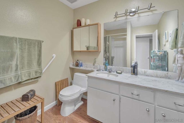 bathroom with toilet, walk in shower, hardwood / wood-style floors, and vanity