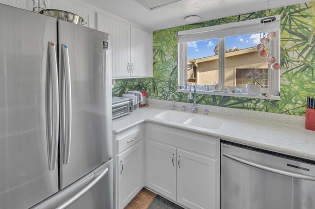 kitchen featuring sink, stainless steel appliances, and white cabinetry