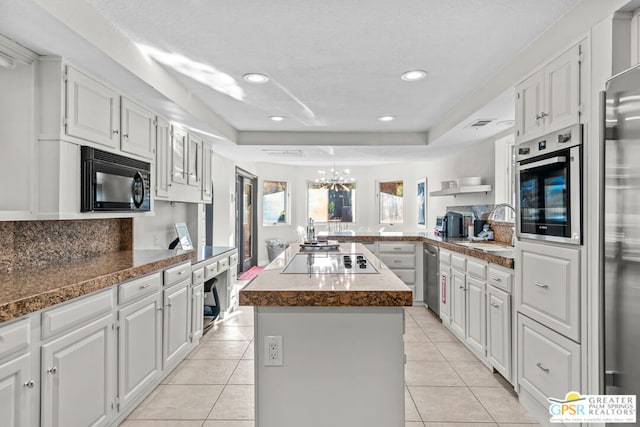 kitchen with white cabinets, a center island, and black appliances