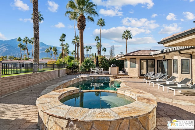 view of pool with a mountain view, an in ground hot tub, and a patio