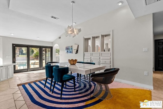 dining space with light tile patterned flooring, a chandelier, and lofted ceiling