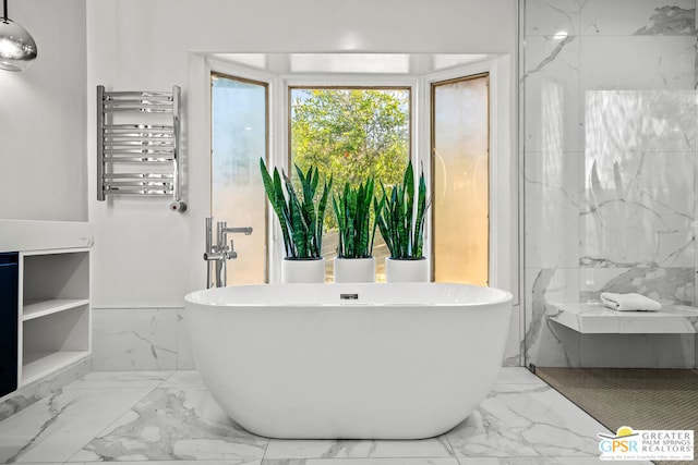 bathroom with a tub, radiator, and tile walls