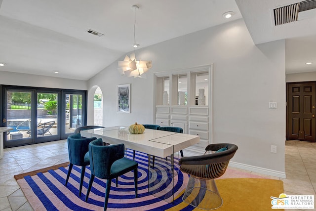 dining area with light tile patterned floors, lofted ceiling, and an inviting chandelier