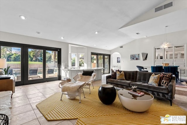 living room featuring plenty of natural light, lofted ceiling, light tile patterned floors, and french doors