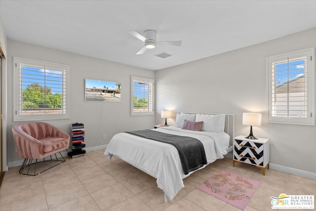 bedroom featuring ceiling fan, light tile patterned flooring, and multiple windows