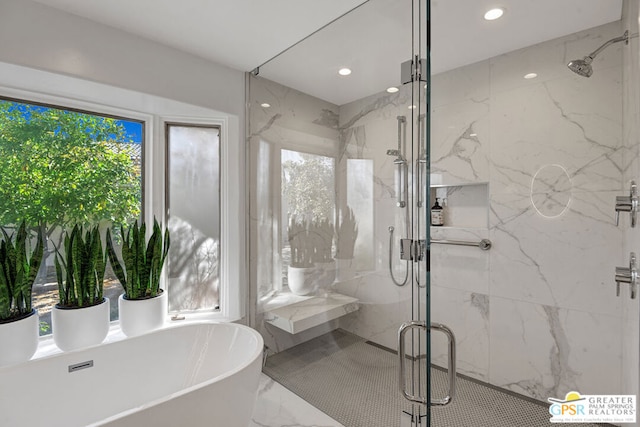 bathroom with shower with separate bathtub and a wealth of natural light