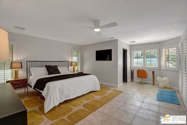 tiled bedroom featuring multiple windows and ceiling fan