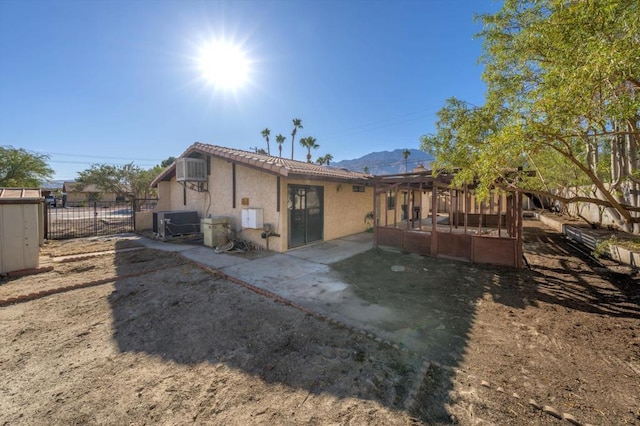 rear view of house featuring a mountain view and a patio