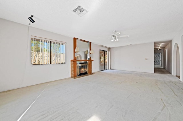 unfurnished living room with light colored carpet and ceiling fan