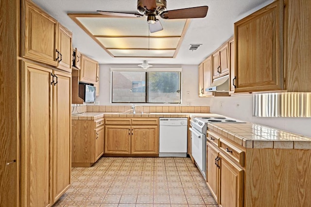 kitchen featuring white appliances, tile countertops, ceiling fan, and sink