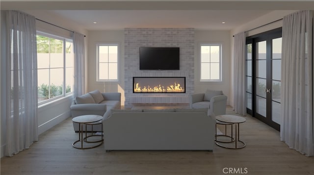 living room with a brick fireplace and light wood-type flooring