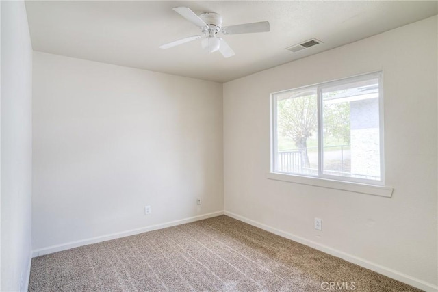 empty room featuring ceiling fan and carpet