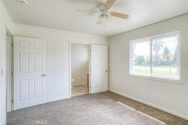 unfurnished bedroom with carpet flooring, ensuite bath, and ceiling fan