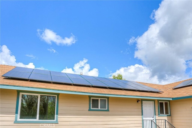 view of side of home featuring solar panels