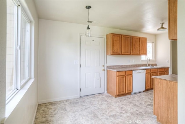 kitchen featuring decorative light fixtures, white dishwasher, and sink