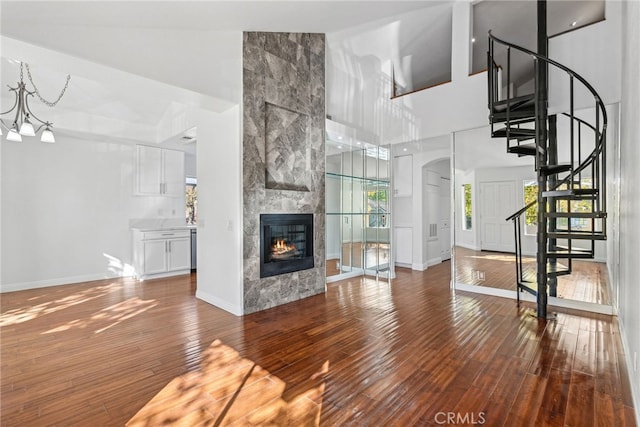 unfurnished living room featuring beam ceiling, a fireplace, high vaulted ceiling, and wood-type flooring