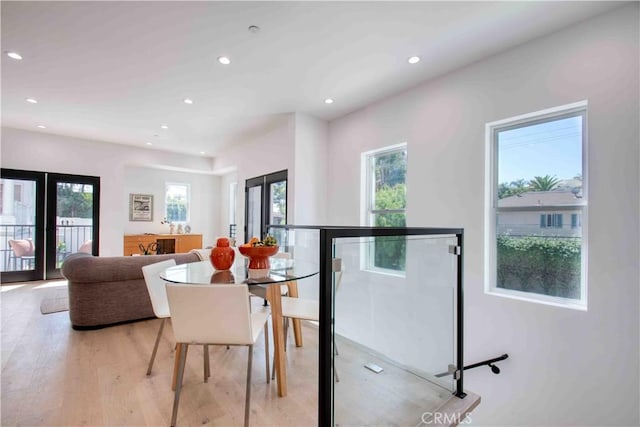 dining space with french doors, light hardwood / wood-style flooring, and a wealth of natural light