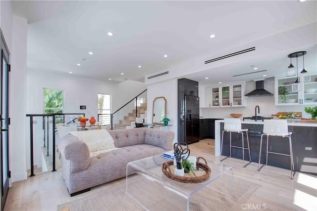 living room featuring light wood-type flooring and sink