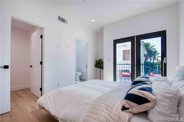 bedroom with access to exterior, french doors, connected bathroom, and light hardwood / wood-style floors