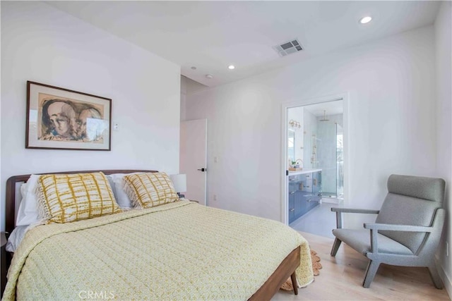 bedroom with hardwood / wood-style flooring and connected bathroom