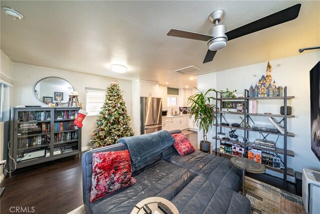 living room with ceiling fan and dark wood-type flooring