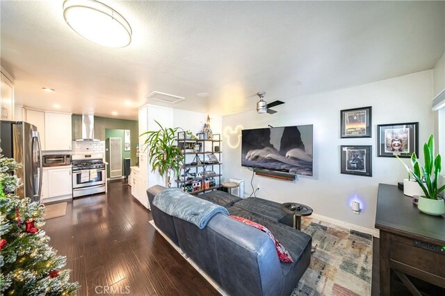 living room with ceiling fan and dark wood-type flooring