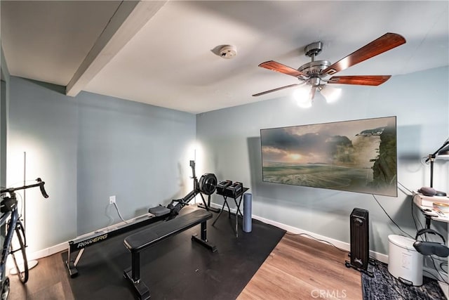 exercise area with wood finished floors, a ceiling fan, and baseboards