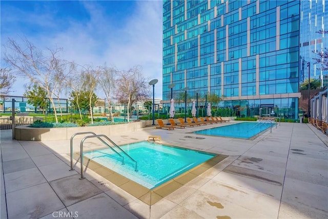 view of pool featuring a patio area and a hot tub