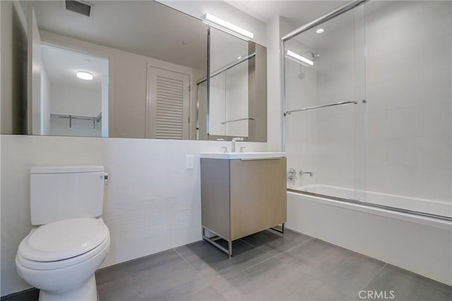 full bathroom with vanity, toilet, and shower / bath combination with glass door