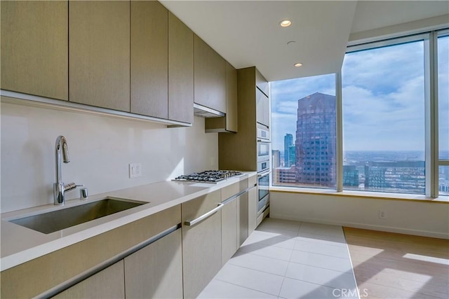 kitchen with light tile patterned floors, stainless steel gas stovetop, and sink