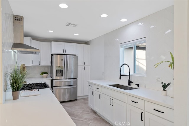 kitchen featuring sink, white cabinets, wall chimney exhaust hood, backsplash, and stainless steel fridge with ice dispenser