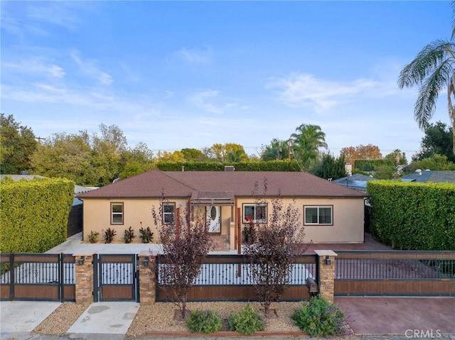 view of front of house featuring a fenced front yard, a gate, and stucco siding