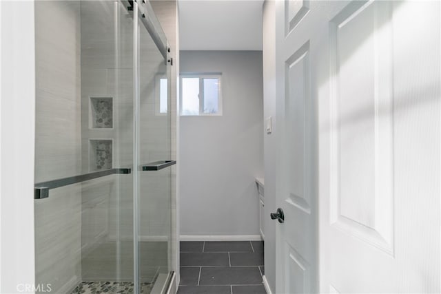 bathroom with an enclosed shower and tile patterned floors