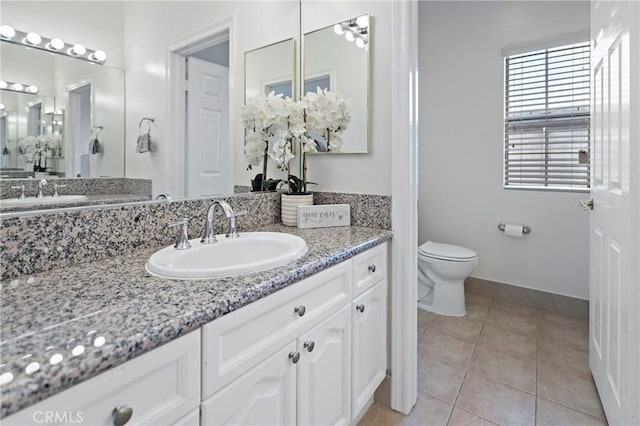 bathroom featuring tile patterned flooring, vanity, and toilet