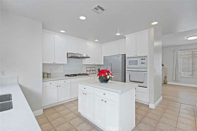 kitchen with white cabinetry, stainless steel appliances, and light tile patterned floors