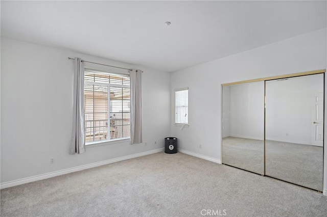 unfurnished bedroom featuring light colored carpet and a closet