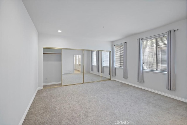 unfurnished bedroom with light carpet and a closet