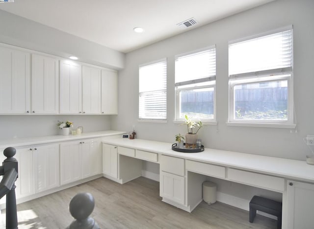 office area with built in desk and light hardwood / wood-style flooring