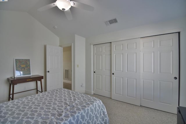 bedroom with ceiling fan, a closet, light carpet, and vaulted ceiling