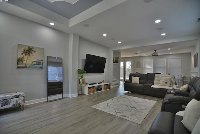 living room featuring light hardwood / wood-style flooring and ceiling fan