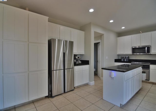 kitchen with light tile patterned flooring, white cabinetry, and appliances with stainless steel finishes