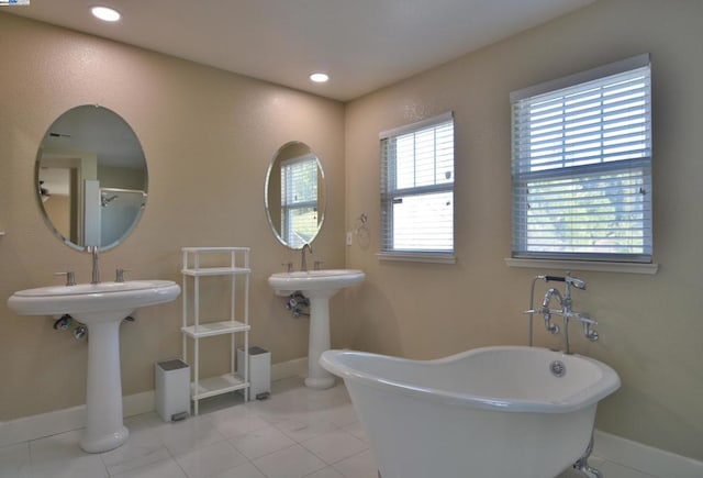 bathroom with a bath and double sink