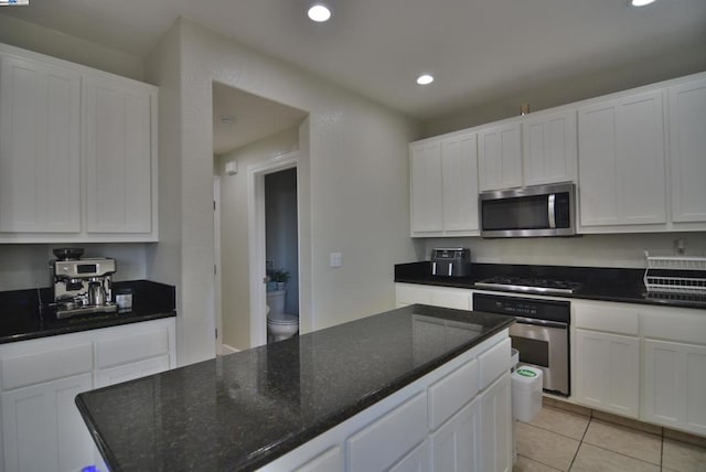 kitchen featuring light tile patterned floors, white cabinetry, and appliances with stainless steel finishes